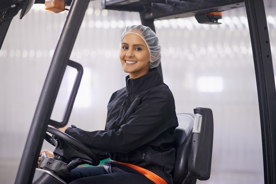 worker driving a forklift in a large warehouse